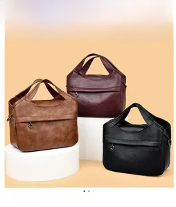 Three vintage leather handbags in brown, burgundy, and black on display stands