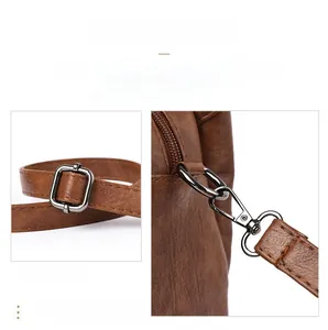 Detailed view of silver metal buckle and spring hook on brown leather handbag