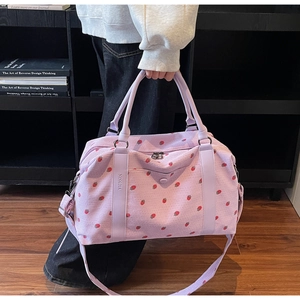 Detail of lavender corduroy travel bag featuring red strawberry print and sturdy handle