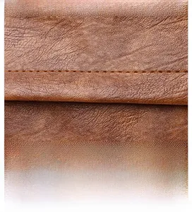 Detailed macro view of the brown leather shoulder strap with reinforced stitching