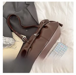 Vue détaillée du sac baguette vintage marron avec boucles métalliques réglables