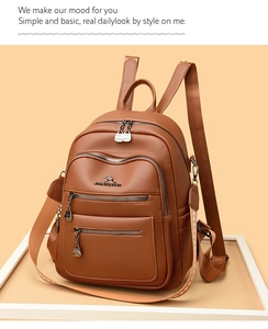 Detail of brown leather backpack with triple zipper pockets and woven shoulder strap