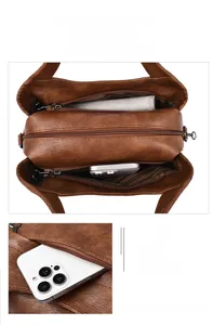 Detail view of brown retro shoulder bag showing multi-compartment interior and front zipper