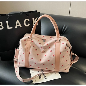 Close-up of pink strawberry print corduroy travel bag with striped texture and zipper detail