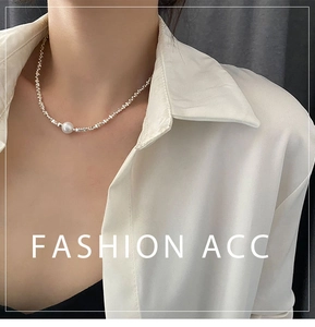 Gros plan d'un collier de perles argentées asymétriques avec perle blanche sur modèle