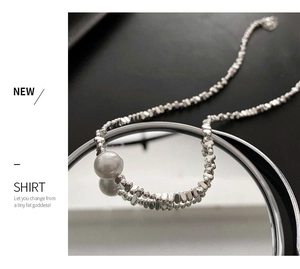 Détail du collier de perles argentées asymétriques avec grand pendentif perle ronde