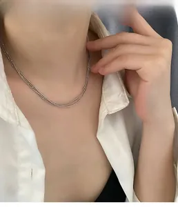 Gros plan d'un collier à trois couches en argent avec des perles sur une chaîne serpent
