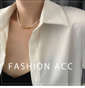 Detail of elegant pearl and gold bead necklace worn with a white minimalist shirt