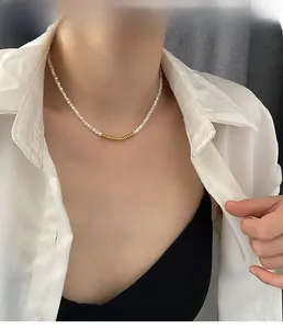 Detailed view of bead necklace on model with golden ring accents and elegant pearls