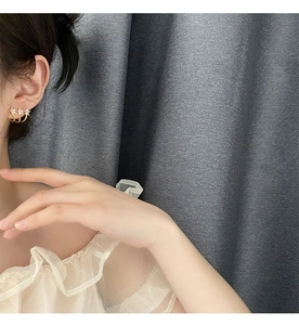 Detailed view of triple gold layered star earrings with micro-zirconia on female model