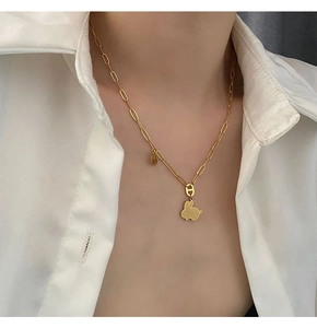 Dettaglio della collana con ciondolo a coniglio dorato e catena a maglie allungate