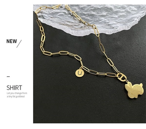 Dettaglio della collana a catena dorata con ciondolo a forma di coniglio e lettera U