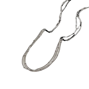 Collier multi-rangs argenté minimaliste avec détails de perles sur fond blanc épuré