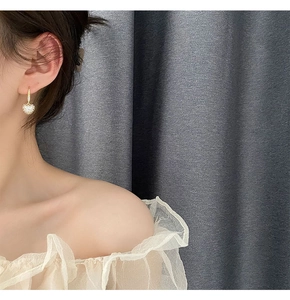 Gros plan de boucles d'oreilles cœur serties de cristaux sur un mannequin femme