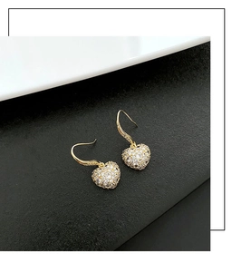 Vue détaillée de boucles d'oreilles cœur avec cristaux pavés et placage d'or