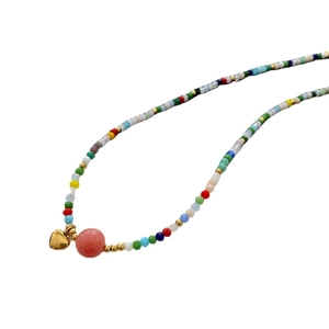 Colorful beaded heart necklace with pink agate pendant and gold accents on white background