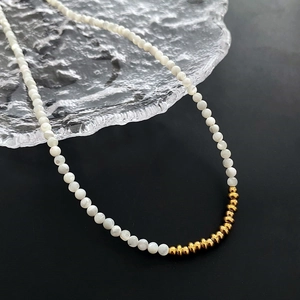 Minimalist beaded necklace with creamy white pearls and golden abacus bead accents