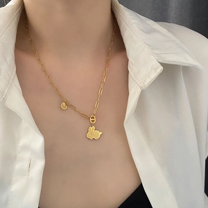 Collana a graffetta dorata con ciondolo a coniglio e charm lettera U indossata da modella
