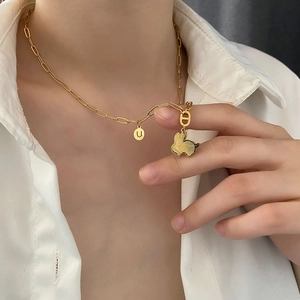 Collana dorata con ciondolo a coniglio e lettera U su catena a graffetta indossata
