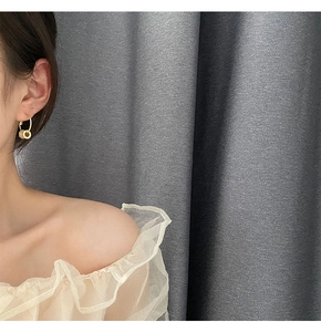 Detailed close-up of elegant gold dangle earrings with sparkling zircon pave on a model