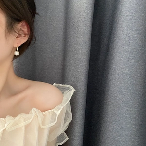 Boucles d'oreilles cœur dorées avec strass blancs sur modèle pour un style de luxe chic