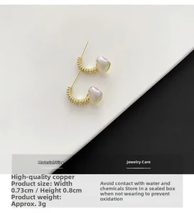 Detail shot of heart-shaped pearl copper earrings with 0.73cm width and 0.8cm height
