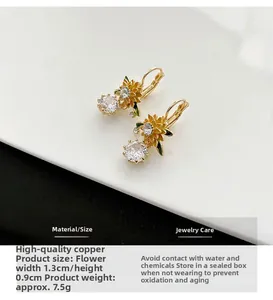 Close-up of golden sunflower earrings featuring white crystal zircon and premium copper
