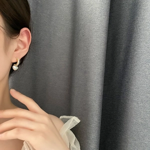 Elegant 18K gold-plated heart pearl earrings with pavé zircon crystals on a female model