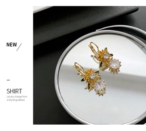 Macro shot of sunflower earrings with yellow enamel petals and large clear cubic zirconias