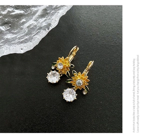 Detail of sunflower drop earrings with yellow enamel and sparkling white zircon stones