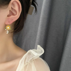 Elegant sunflower drop earrings with yellow enamel and zircon stones worn by a model