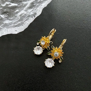 Luxurious sunflower earrings with yellow petals and brilliant crystal zircons on black background