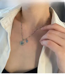 Détail d'un collier de perles colorées avec pendentifs fleur et cœur sur un mannequin