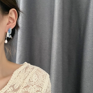 Elegant butterfly wing earrings with blue gradient wings and dangling white teardrop pearl