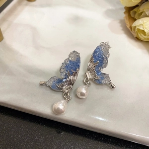 Elegant butterfly wing earrings with blue crystals and hanging white teardrop pearls