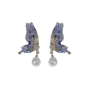 Exquisite butterfly wing earrings with purple crystals and teardrop pearls on white background