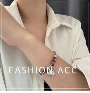 Detailed view of handmade ceramic beaded bracelet with a silver Ruyi lock pendant