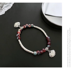 Detail of ceramic bracelet with vintage silver longevity locks and kiln-fired beads