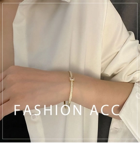 Détail d'un bracelet doré avec zircon rectangulaire et diamants pavés sur poignet
