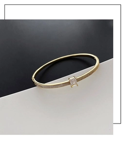 Détail d'un bracelet doré avec zircon rectangulaire et accents de micro-pavage chic