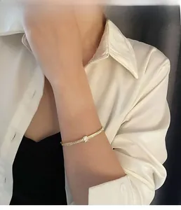 Détail d'un bracelet fin en or avec zircon rectangulaire et sertissage pavé étincelant