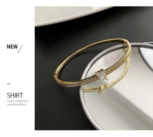 Vue détaillée du bracelet doré ouvert avec zircon rectangulaire et pavé de cristaux