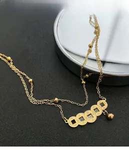 Macro detail of retro gold titanium anklet with five ancient Chinese coins on leather