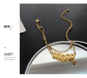 Detailed shot of double-layered gold anklet featuring five miniature ancient copper coins