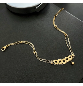 Detail of gold double-layered anklet featuring five miniature ancient coins on black leather