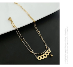 Macro detail of double-layered gold anklet featuring five vintage coin charms on a plate
