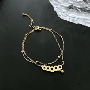 Double-layered gold titanium steel anklet featuring five ancient coin charms on black background