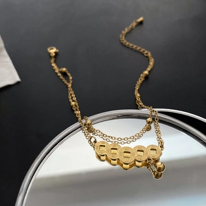 Vintage double-layer gold anklet with five ancient coins on a mirror background