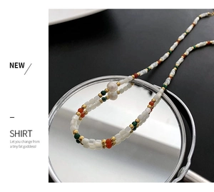 Macro view of freshwater pearl necklace with colorful beads reflected in a round mirror