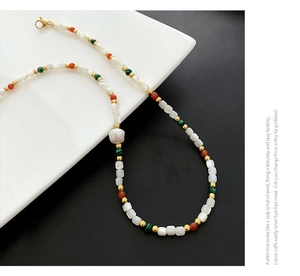Detail of bohemian necklace with baroque pearl, malachite beads and golden lobster clasp